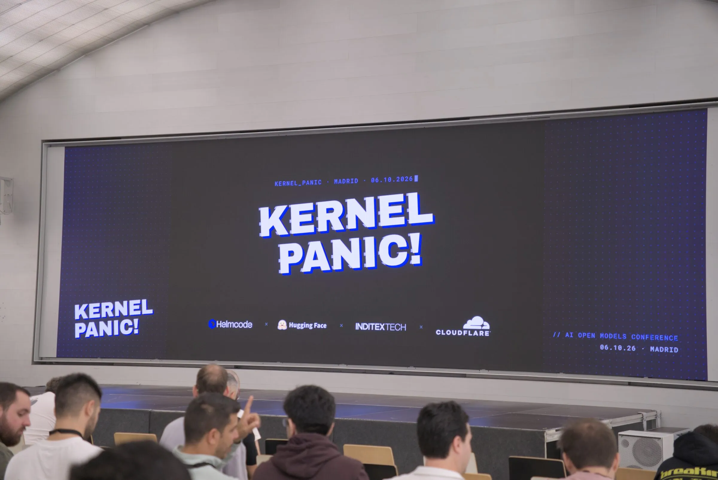 El público frente a la pantalla con el logo de Kernel Panic! antes de empezar