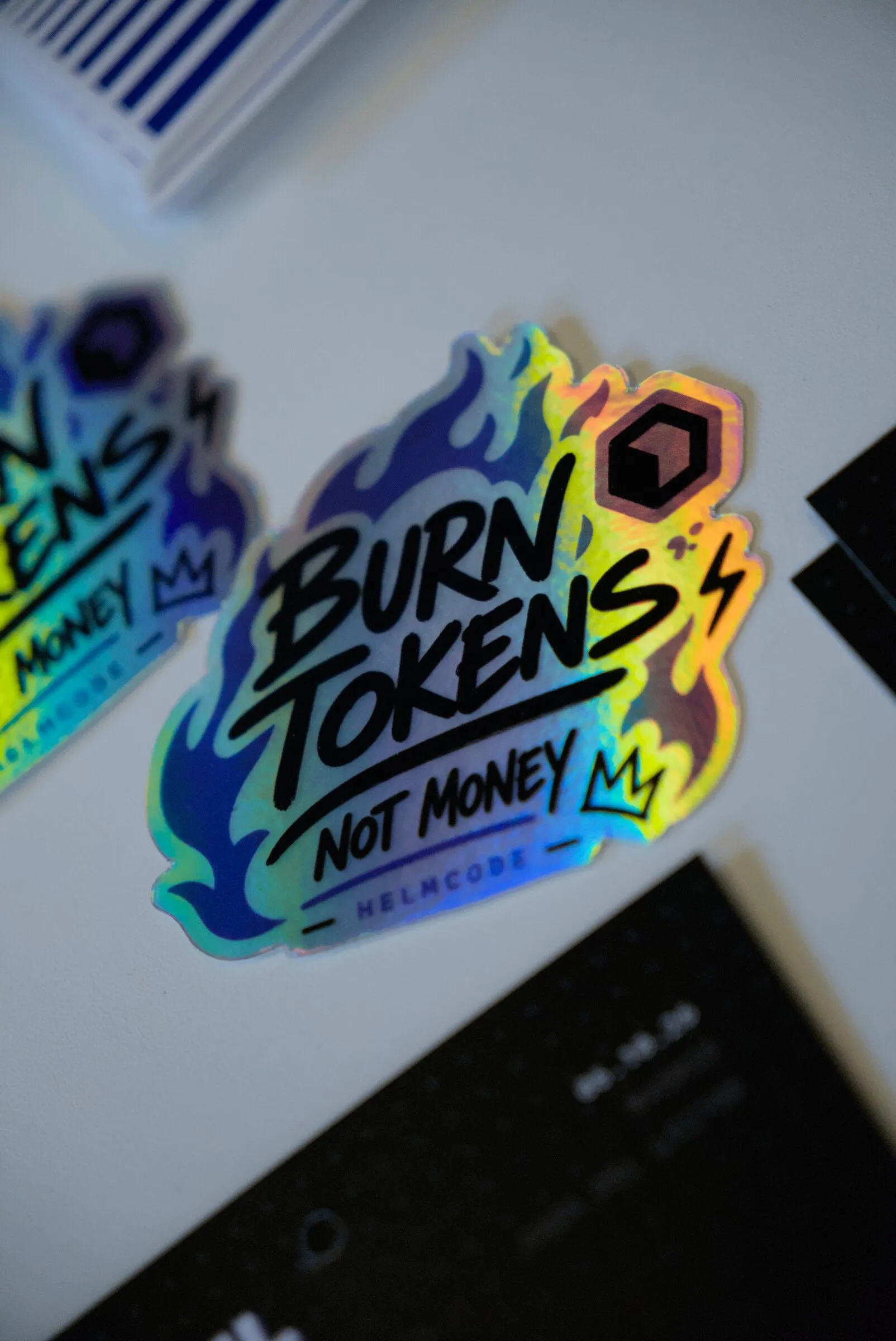 Sticker holográfico de Helmcode: «Burn tokens, not money»